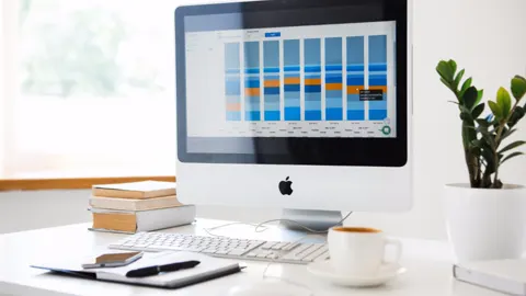 Computador em uma mesa mostrando um painel com gráficos de resultados